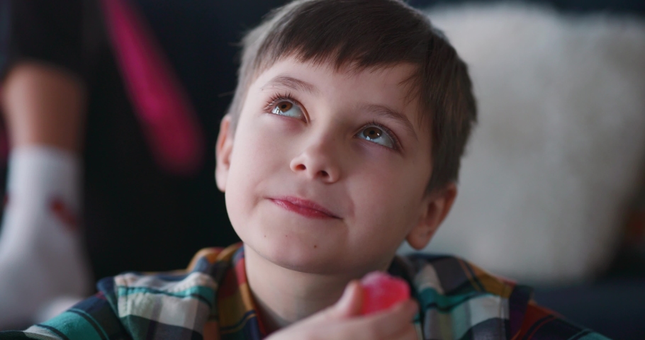 Close-up portrait of cute child boy eating a tasty candie closing eyes in satifaction enjoying leisure activity. Sugar addiction concept. Royalty-Free Stock Footage #1067663621