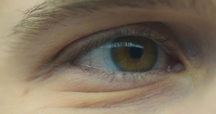 Male eye with contact lens blinking close up. Man's brown eye macro shoot. Healthy eyesight, vision correction. 4K video