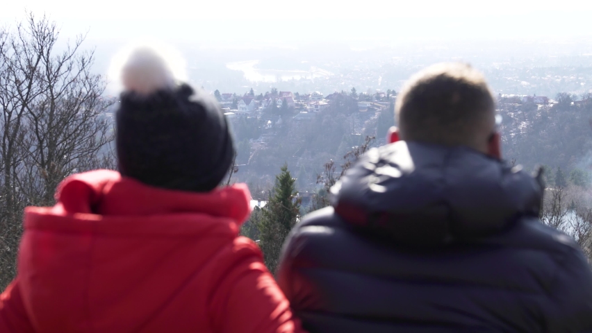Couple looking at the landscape on the mountain peak.