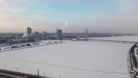 Riga, Latvia, Baltics. Beautiful panoramic aerial 4K video from flying drone on Stone and cable-stayed bridge  on the background of the Daugava River and downtown on a beautiful sunny winter day. 