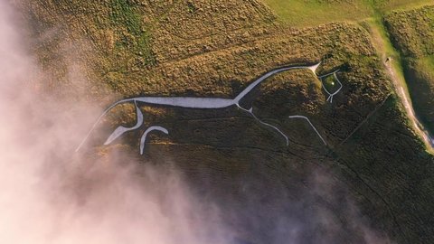 4k rising birds-eye footage of Uffington White Horse in Oxfordshire. The Uffington White Horse is a prehistoric hill figure, 110 m long, formed from deep trenches filled with crushed white chalk.