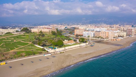 Aerial drone hyperlapse timelapse of Fuengirola beachfront in Spain in winter with fasting clouds