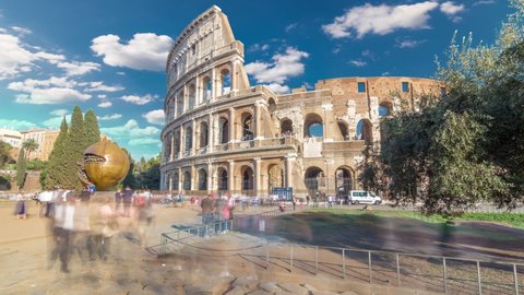 ROME, ITALY - CIRCA JULY 2019: Many tourists visiting The Colosseum or Coliseum timelapse hyperlapse, also known as the Flavian Amphitheatre in Rome, Italy. Green lawn and monument. Blue sky with