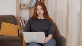 Video chat job interview or distance course with red hair female online teacher. Happy young woman conference call speak looking at computer at home.