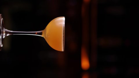 Vertical Screen. Close up rotating glass of Sidecar cocktail.
