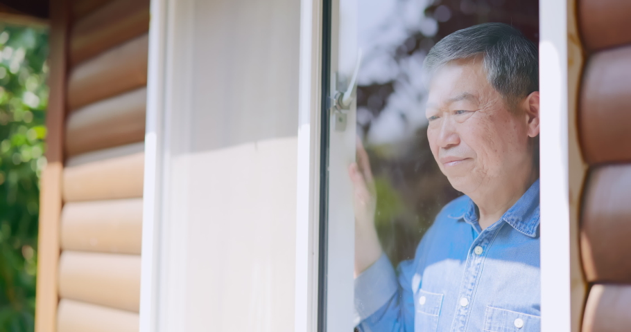 Asian senior man stays isolation at home for self quarantine due to epidemic of COVID19 - he looks out of window | Shutterstock HD Video #1067696240