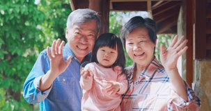Authentic close up of asian retired grandparents with their granddaughter have video chat on smart phone when they traveling