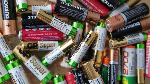 KRASNODAR, RUSSIA - 19 february, 2021 Batteries background. Old used discarded AA cells and other electric batteries from different manufacturers, waste, collection and recycling, high danger