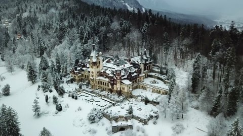Drone video of Peles Castle in Sinaia during winter. Peles Castle covered in snow panoramic and scenic video.