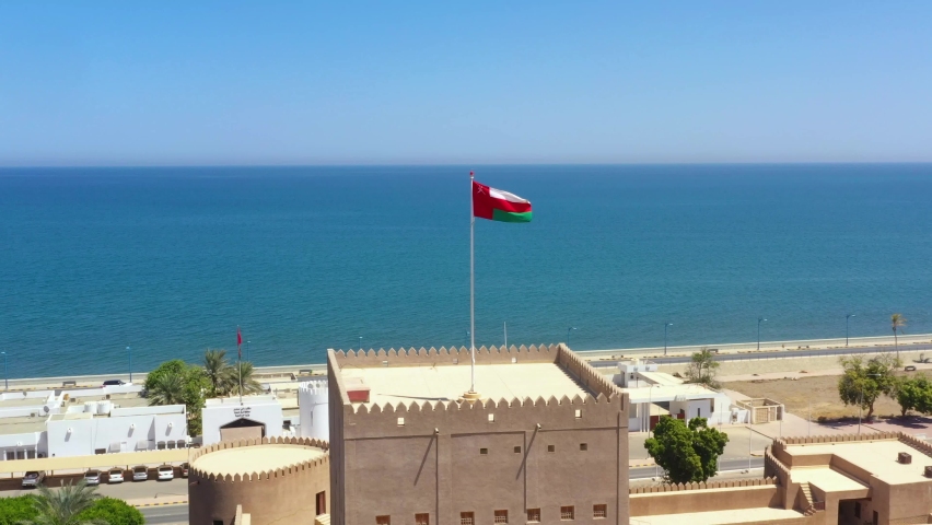 Aerial view of Omani flag at the top of Sohar Fort in the city of Sohar at Al Batinah North governorate Royalty-Free Stock Footage #1067711225