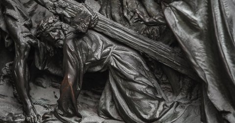 Anceint statue of Jesus dragging cross for crusifixion to Golgotha pictured on main gates of Duomo di Milano,main christian catholic church in Italy