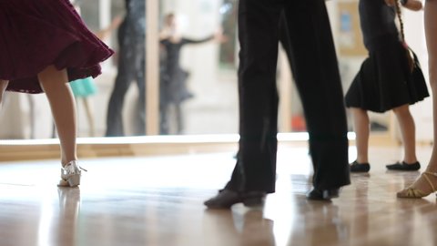 Unrecognizable male and female ballet dancers rehearsing in front of mirror in dancing school. Caucasian boys and girls practicing dance in studio indoors. Children learning classical ballet.