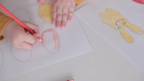 Children's hands are drawing. Preparing for Easter