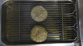 Grilled buns for hamburgers on the grill. Grilled brown bread. Barbecue. Delicious tasty dish on grid. Video from the top.