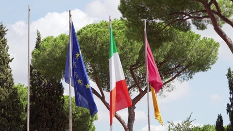 Three flags waving in wind against blue sky. Close up of Italian, European Union and flag of Rome city on Capitoline hill