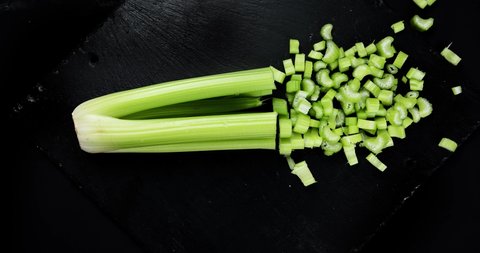Cutting celery plant. Healthy and detox food concept.  Stop motion animation, 4K.