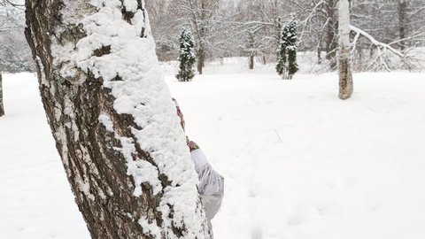 Little smiling girl peeking out from behind a tree. Shrovetide (Maslenitsa) Concept