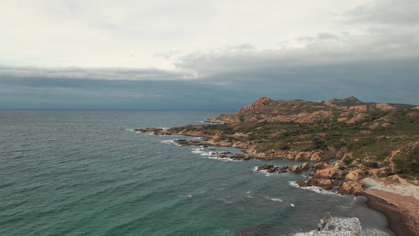Aerial view of Mediterranean waves washing onto the rocky coastline of the Desert des Agriates at Ostriconi in the Balagne region of Corsica
