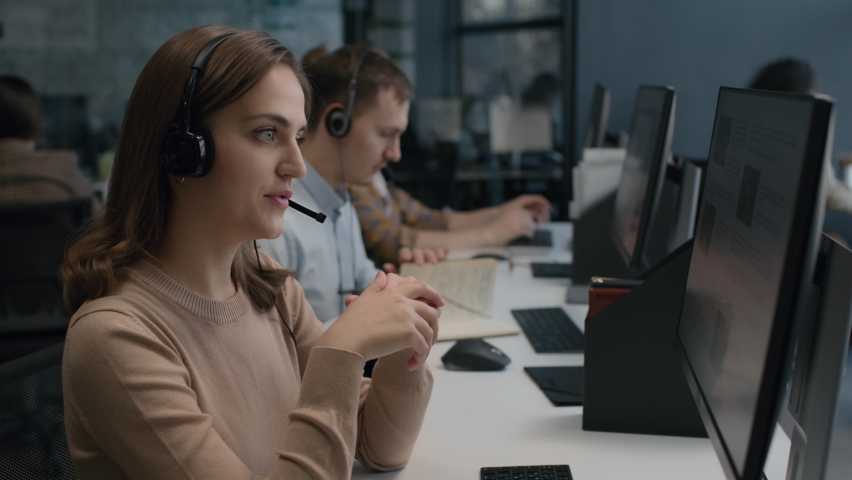 Call center and helpful customer service. Use pc computer and answer questions on phone line at modern co-working. Diverse group of people talks on sale hotline. Busy seller at agency office closeup. Royalty-Free Stock Footage #1067750939