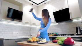 cooking online. healthy food. Woman blogger taking selfie, shooting video about vegetarian lunch on smartphone for social media, at home kitchen. culinary vlogging, social networks.