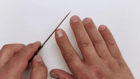 Close-up of a nail file treats the index finger of a man's hand. The master teaches and shows the techniques of work. Professional care, DIY manicure. Isolated video on a white background.