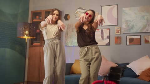 Teenagers womans shooting together dancing at home when making video for social media, stories hip hop popular trandy dance, students at home make content