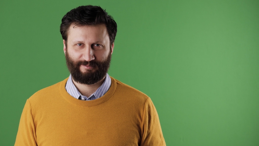 Man holding number 2 sign. Cheerful white bearded good-looking man in yellow sweater shows number 2 two on white sheet. Chrome key, green screen, copy space