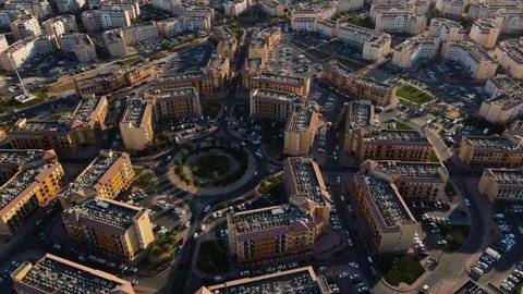 Slow motion aerial view of International City in Dubai, United Arab Emirates. Suburban country-themed architecture of residences, business, and tourist attractions outside of Dubai downtown in the UAE