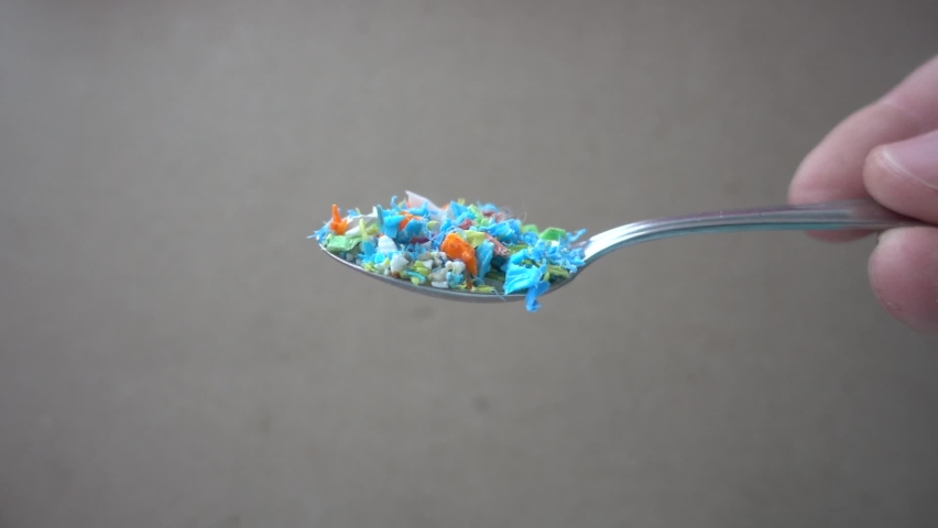 Side view of microplastics falling down from a spoon. Slow-motion of waste non-recyclable plastic. Selective focus on the spoon. Microplastics being poured from a metal spoon. | Shutterstock HD Video #1067762045