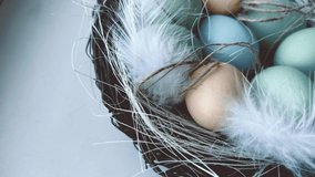 Stylized Easter video card with colorful eggs in nest and with moving feathers and straw