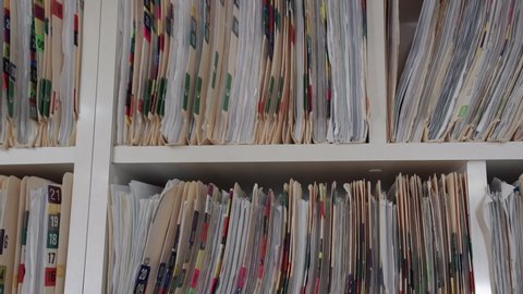 Medical cards on shelves in hospital. Health insurance folders in archive files. Records and catalogs in medicine clinic. Patient healthcare information