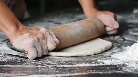 making pizza the process ,Making dough by male hands,pizza prepare dough by rolling pin.