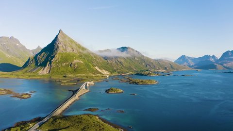 Flying above Fredvang bridge with mountains in the background on Lofoten islands in Norway. 4K UHD video.
