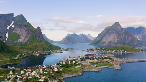 Flying above Reine fishing village surrounded by high mountains and fjords on Lofoten islands in Norway. 4K UHD video.