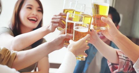 slow motion of group of asian happy friends drinking and toasting beer in restaurant