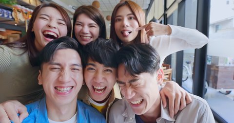 slow motion of asian young six friends taking selfie in restaurant happily
