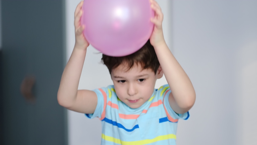 surprised cheerful boy with thorns in his hair without static electrification. Physics, electrical electrification balloon test. Positively and negatively charged atoms. School lesson experiment. Royalty-Free Stock Footage #1067802140