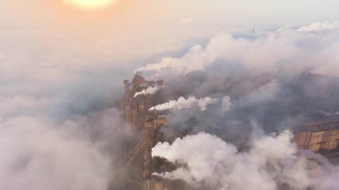 Plant pipes pollute atmosphere. Industrial factory pollution, smokestack exhaust gases. Industry zone, thick smoke plumes. Climate change, ecology. Epic aerial of smoke stack. 4k
