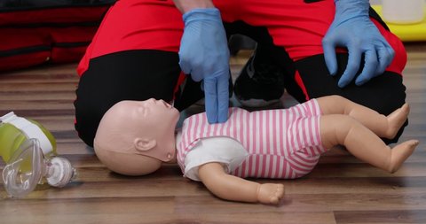 Giving first aid on a child dummy. Practitioners training medical learning on a baby mannequin. Emergency course for resuscitation. First aid training.