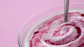 Yogurt with berry jam in spoon, curd cream swirl with fruit topping, blueberry whipped cream, ProRes uncompressed video - Powered by Shutterstock - Get 15% off with code: PIKWIZARD15