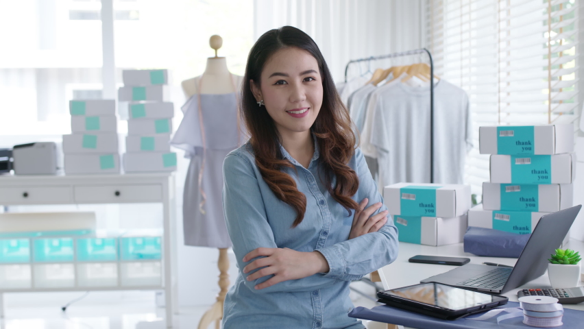 Portrait young attractive asia female owner startup business look at camera work happy with box at home prepare parcel delivery in sme supply chain, procurement, omnichannel ecommerce online concept. | Shutterstock HD Video #1067809502