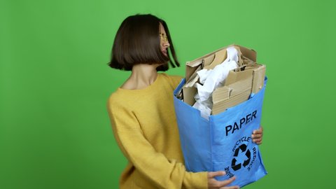 Woman holding a recycling bag full of paper to recycle doing NO gesture over isolated background