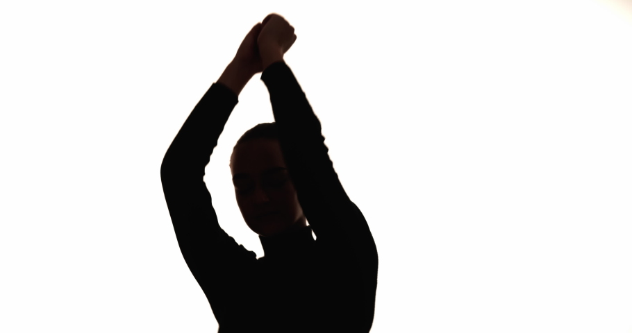 Carefree woman silhouette. Positive lifestyle. Fun joy. Freedom relaxation. Dark contrast outline of inspired lady enjoying dance movements isolated on white copy space background.