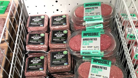 Alameda, CA - Feb 20, 2021: 4K HD video panning down frozen Beyond Beef and Impossible Burger Patties in grocery freezer section. Plant based proteins can be as healthy as animal based proteins.