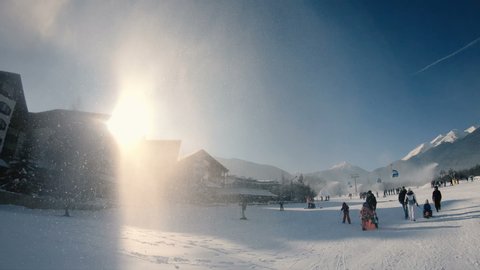 Bansko, Bulgaria - 22 Feb, 2019: Bansko cable car cabin in Bansko, Bulgaria, people skiing. Snow mountain peaks at the background, slow motion