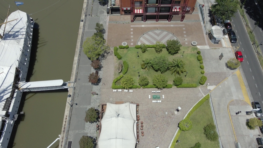 Drone Flying Above Waterfront Restaurants Along Rio Darsena Sur In Puerto Madero, Buenos Aires, Argentina - aerial tilt-up