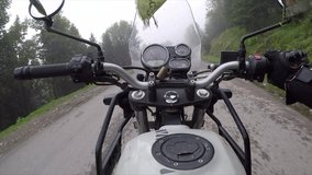 Driving a motorbike at high speed through the Himalayan mountains with fog and pine trees