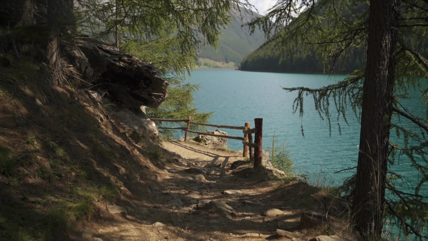 Scenic hiking trail at shoreline of beautiful alpine lake