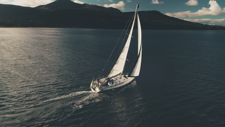 Sailboat at mountain island aerial. Nobody nature seascape. Luxury yacht sailing at open sea. Business cruise at Atlantic ocean bay. Yachting sport. Cross from Caribbean to Europe. Dramatic drone shot Royalty-Free Stock Footage #1067832260
