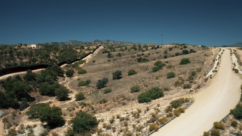 Aerial view of Nogales border area showing border fence separating the United States of America and Mexico with U.S. Border and Customs Protection patrolling border area with their vehicles